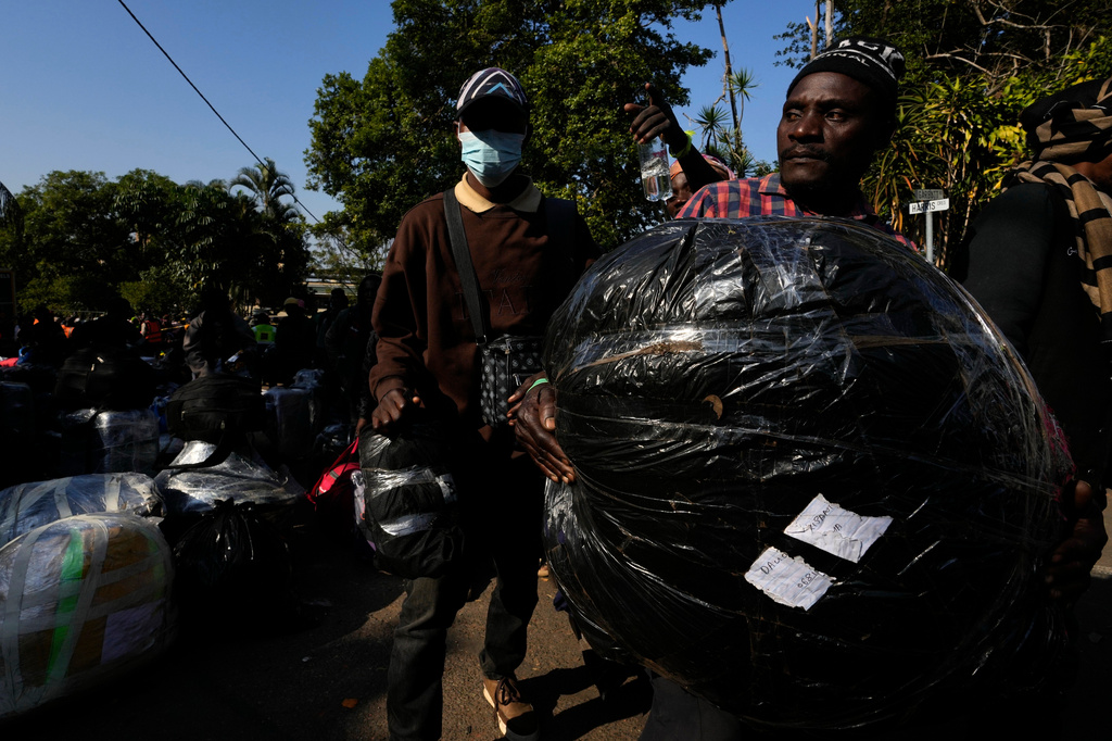 A Malawian man awaiting deportation carries his belongings at a temporary centre, in Durban, South Africa, Thursday, June 18, 2026. (AP Photo/Themba Hadebe)