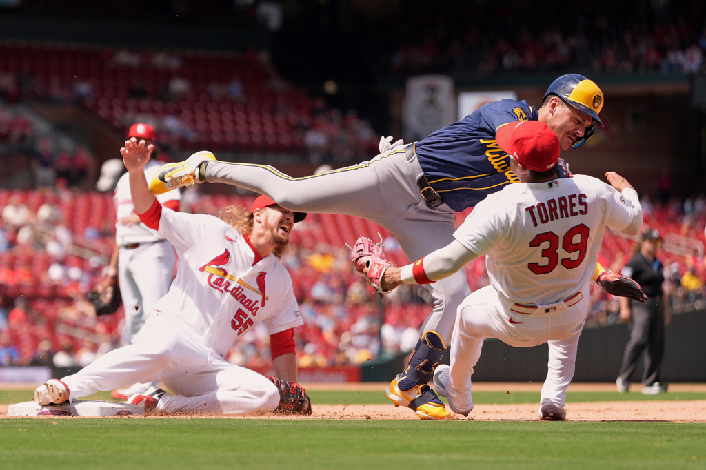 Milwaukee Brewers' Joey Ortiz is safe at first for a single as he collides with St. Louis Cardinals second baseman Bryan Torres (39) and pitcher Ryne Stanek (55) as they cover first base during the seventh inning in the first game of a baseball doubleheader Tuesday, July 7, 2026, in St. Louis. (AP Photo/Jeff Roberson)