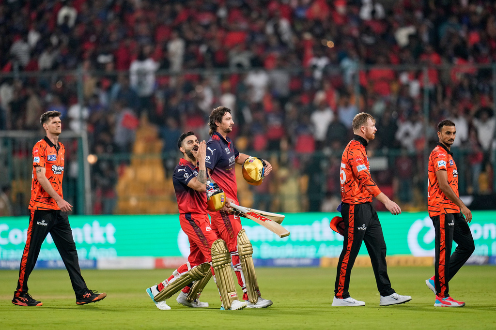 Royal Challengers Bengaluru's Virat Kohli, second left, gestures to the fans as he walks out with teammate Tim David after winning the Indian Premier League cricket match against Sunrisers Hyderabad in Bengaluru, India, Saturday, March 28, 2026. (AP Photo/Aijaz Rahi)