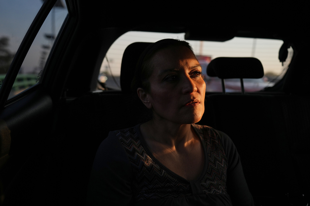 Ninfa Fuentes enters the back seat of a taxi organized by AmorrAs, a feminist transportation collective that offers rides to women who prefer alternatives to public transit due to safety concerns, in Mexico City, Thursday, Nov. 6, 2025. (AP Photo/Claudia Rosel)