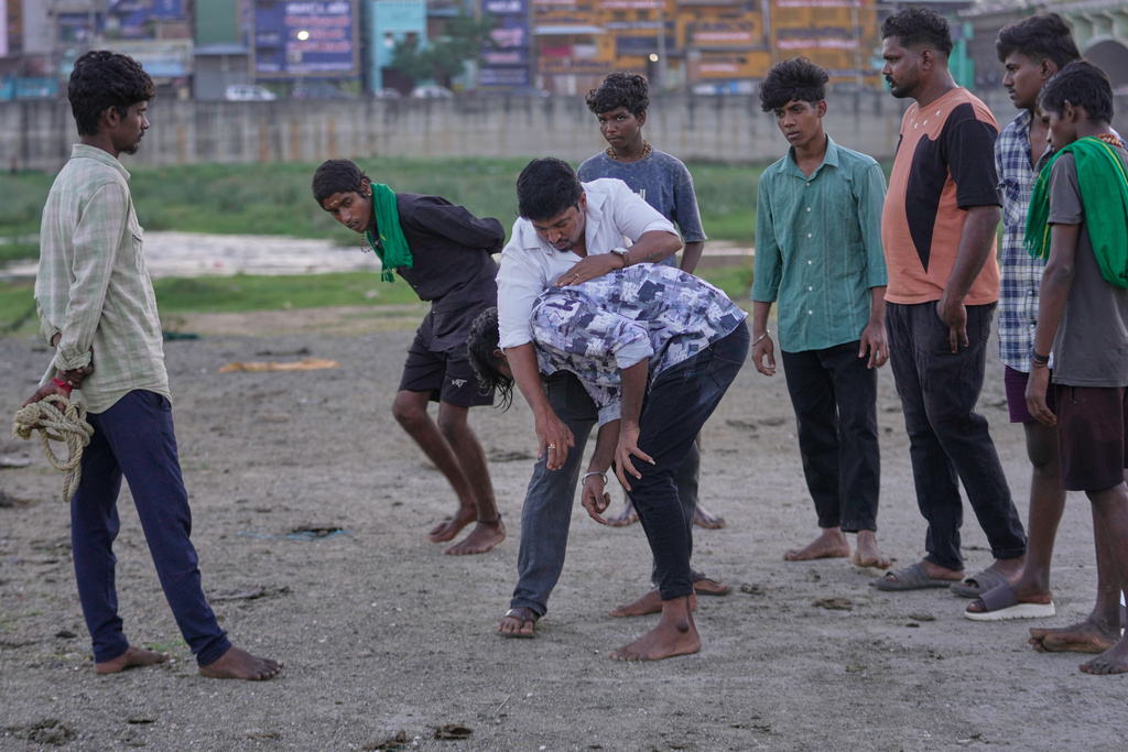Former champion Manikandan Prabhu, center, trains young men for the Jallikattu bull-taming event at the annual harvest festival called Pongal on the outskirts of Madurai, India, Wednesday, Jan. 14, 2026. (AP Photo/Mahesh Kumar A.)
