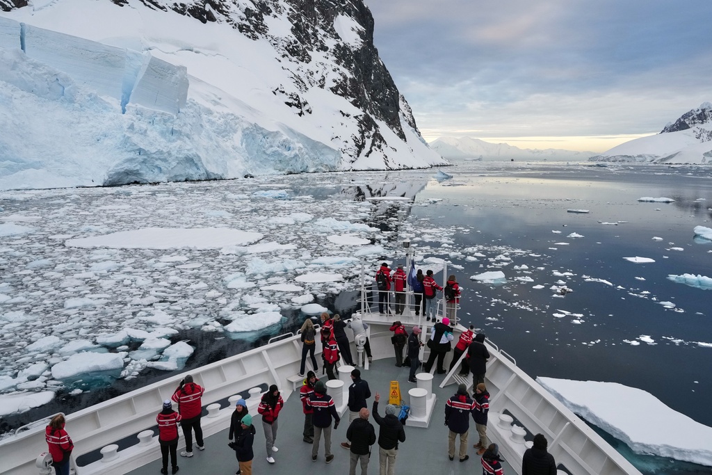 Passengers watch as a ship sails through the Lemaire Channel in Antarctica, Monday, Nov. 24, 2025. (AP Photo/Mark Baker)