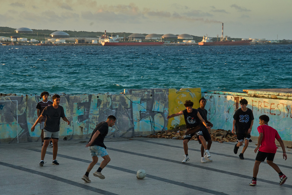 People play soccer in an abandoned swimming pool across from a tanker terminal along the port of Matanzas, Cuba, Monday, March 30, 2026. (AP Photo/Ramon Espinosa)
