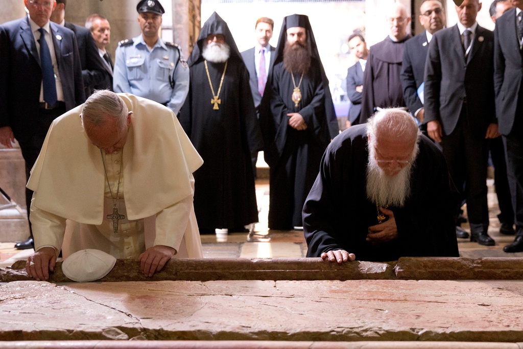 FILE - Pope Francis and Constantinople Patriarch Bartholomew kneel to kiss the Stone of Unction in the Church of the Holy Sepulchre, in Jerusalem, Israel, Sunday, May 25, 2014. (AP Photo/Andrew Medichini, Pool, File)