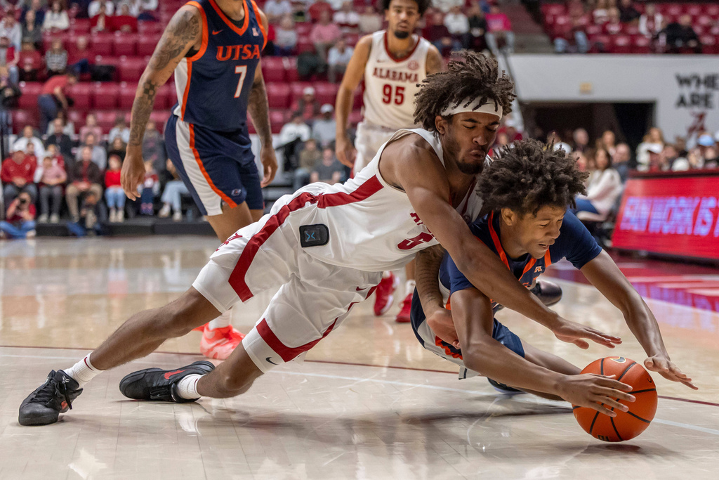 Alabama forward Amari Allen (5) and UTSA guard Dorian Hayes, right, dive for the ball during the first half of an NCAA college basketball game, Sunday, Dec. 7, 2025, in Tuscaloosa, Ala. (AP Photo/Vasha Hunt)