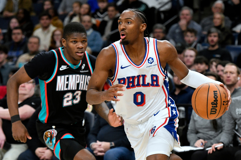 Philadelphia 76ers guard Tyrese Maxey (0) handles the ball ahead of Memphis Grizzlies guard Cedric Coward (23) in the second half of an NBA basketball game Tuesday, Dec. 30, 2025, in Memphis, Tenn. (AP Photo/Brandon Dill)