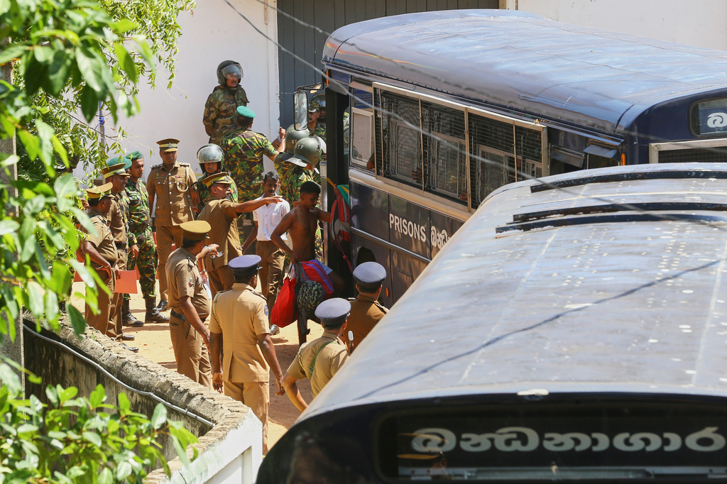 Security personnel escort prisoners to a bus in the compound of a prison where deadly clashes broke out on Sunday, in Negombo, 35 kilometers (22 miles) north of the capital Colombo, Sri Lanka, Monday, July 6, 2026. (AP Photo)