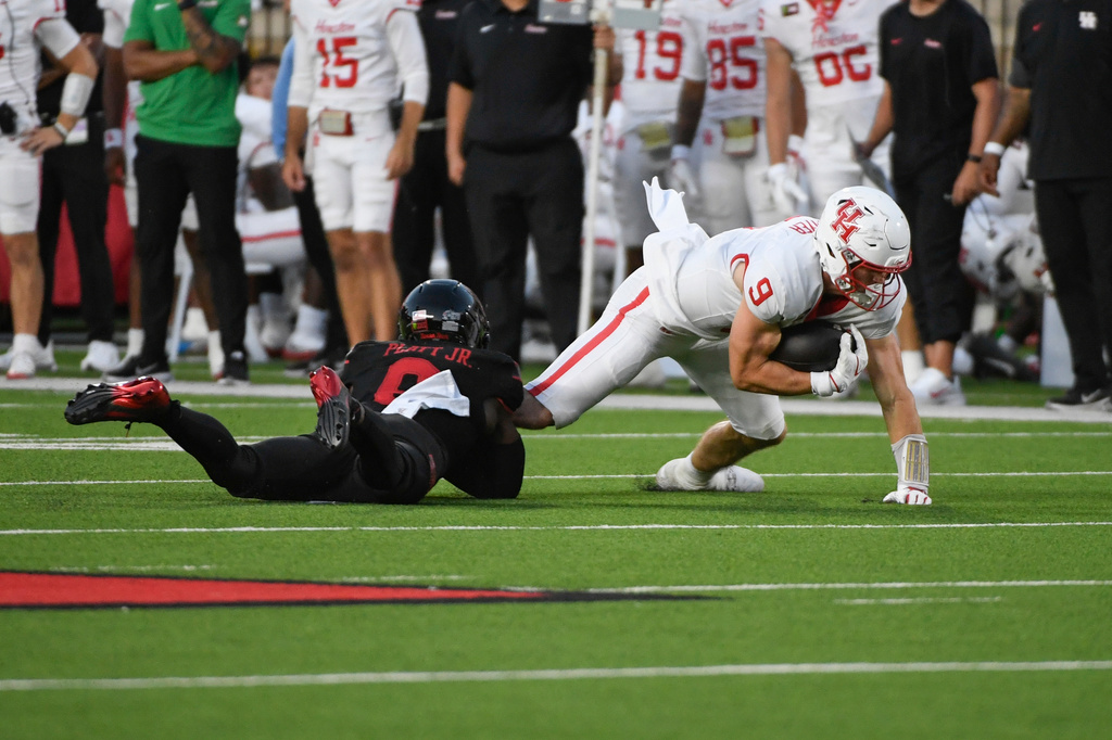 Texas Tech linebacker Corey Platt Jr., left, tackles Houston tight end Patrick Overmyer (9) during the first half of an NCAA college football game Friday, Sept. 18, 2026, in Lubbock, Texas. (AP Photo/Justin Rex)