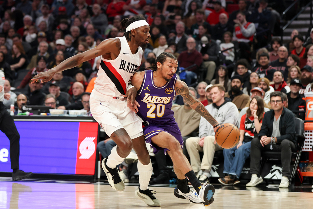 Los Angeles Lakers guard Nick Smith Jr. (20) drives to the basket as Portland Trail Blazers forward Jerami Grant, left, defends during the first half of an NBA basketball game Monday, Nov. 3, 2025, in Portland, Ore. (AP Photo/Amanda Loman)