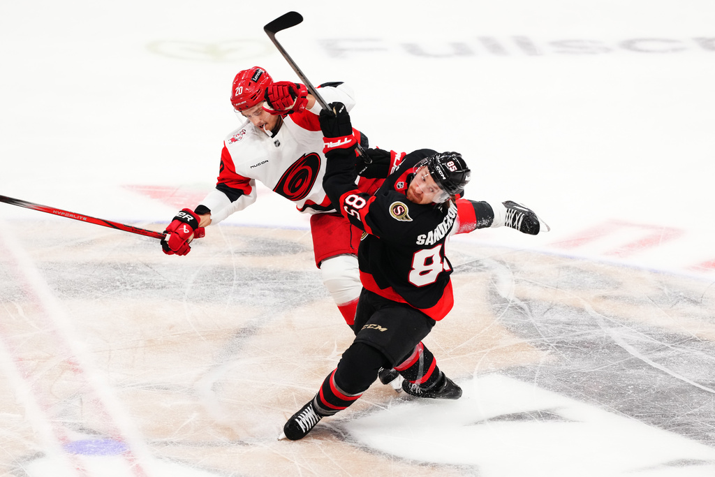 Carolina Hurricanes' Sebastian Aho (20) and Ottawa Senators' Jake Sanderson (85) collide during second period of an NHL playoff hockey game in Ottawa on Thursday, April 23, 2026. (Sean Kilpatrick/The Canadian Press via AP)