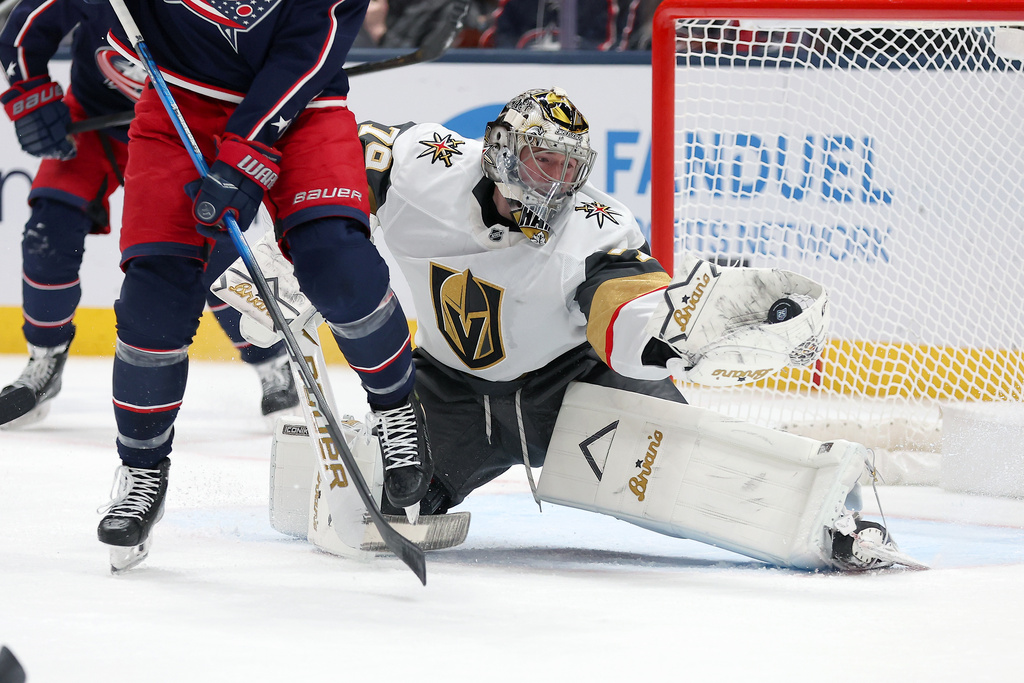 Vegas Golden Knights goaltender Carter Hart (79) saves the puck during the first period of an NHL hockey game against the Columbus Blue Jackets, Saturday, Dec. 13, 2025, in Columbus, Ohio. (AP Photo/Joe Maiorana)