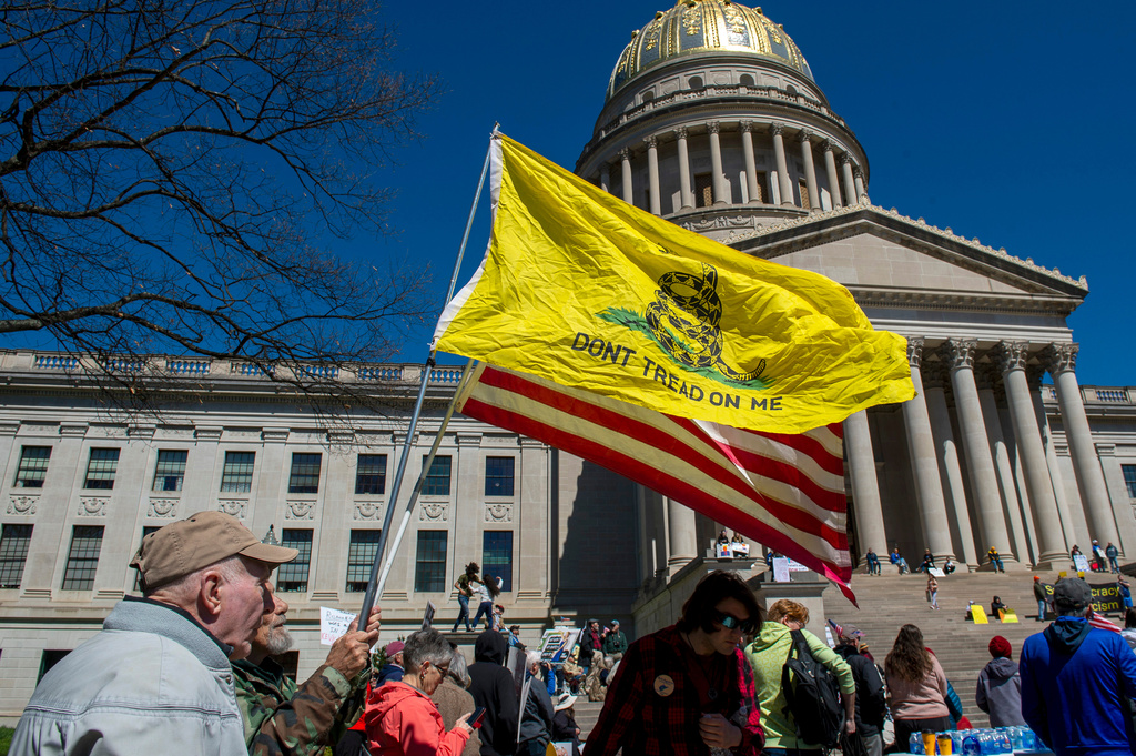 Timothy Richardson (second from left) holds a 'Don't Tread on Me" flag and American flag at the 'No Kings' protest near the south steps of the West Virginia State Capitol in Charleston, West Virginia on Saturday, March 28, 2026. (Laura Bilson/Charleston Gazette-Mail via AP)