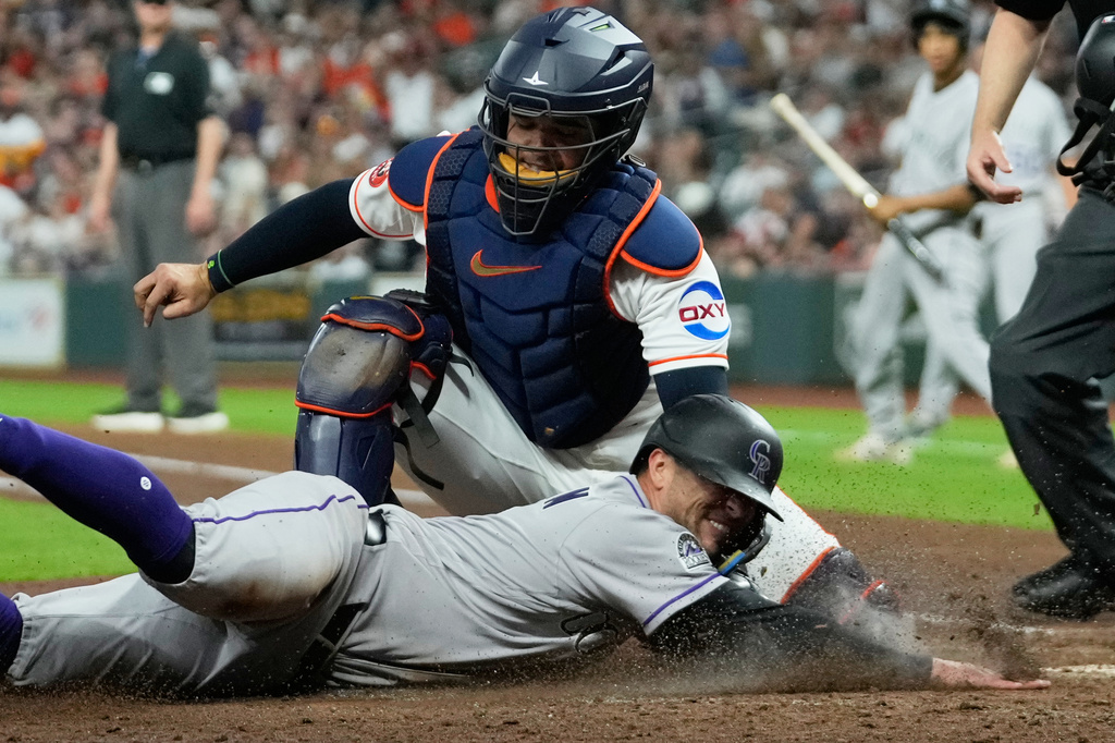 Colorado Rockies' Tyler Freeman, bottom, is tagged out at home plate by Houston Astros catcher Yainer Diaz (21) during the fifth inning of a baseball game Thursday, April 16, 2026, in Houston. (AP Photo/David J. Phillip)