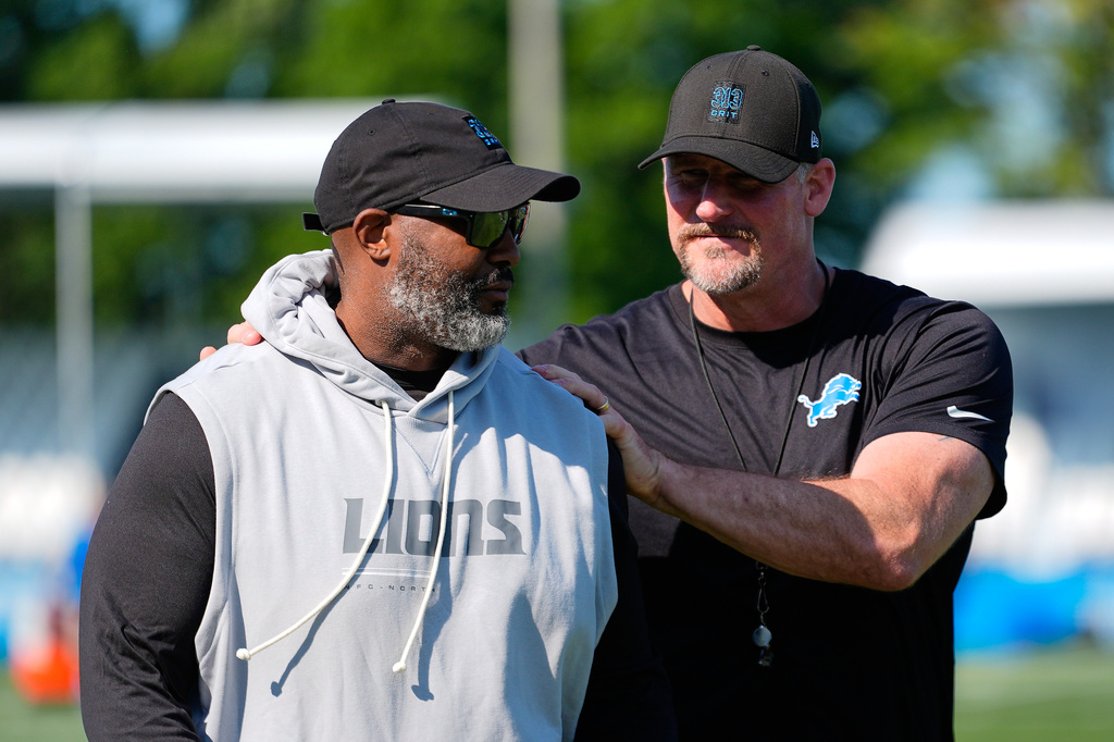 Detroit Lions general manager Brad Holmes, left, and head coach Dan Campbell, right, talk after a NFL football training camp practice in Allen Park, Mich., Wednesday, July 29, 2026. (AP Photo/Paul Sancya)