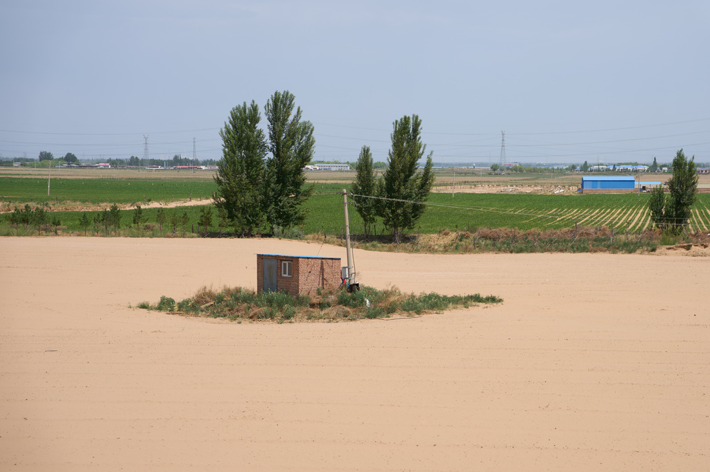A shed is surrounded by a sandy plain near Ordos in northern China's Inner Mongolia province on Friday, June 12, 2026. (AP Photo/Ng Han Guan)