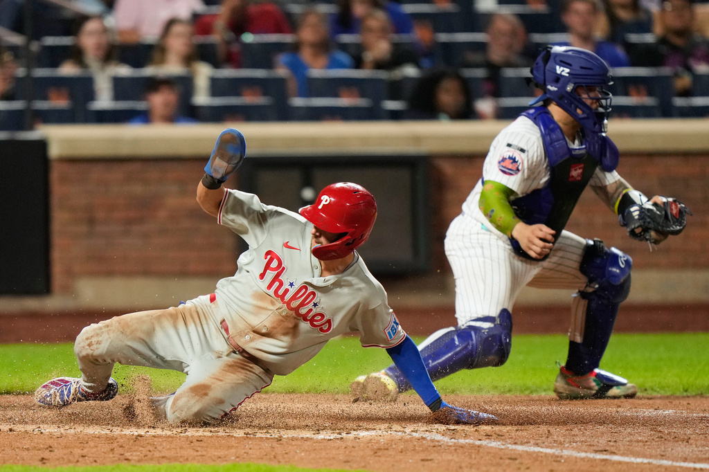 Philadelphia Phillies' Trea Turner, left, slides home past New York Mets catcher Francisco Alvarez on a sac fly hit by Luis Arraez during the seventh inning of a baseball game, Thursday, Sept. 17, 2026, in New York. (AP Photo/Seth Wenig)