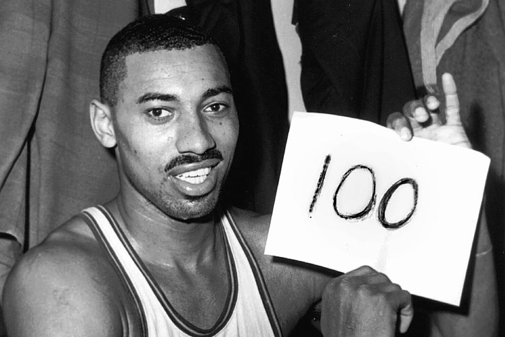 FILE - Philadelphia Warriors' Wilt Chamberlain holds a sign reading, "100," in the dressing room after he scored 100 points against the New York Knickerbockers, March 2, 1962, in Hershey, Pa. (AP Photo/Paul Vathis, File)