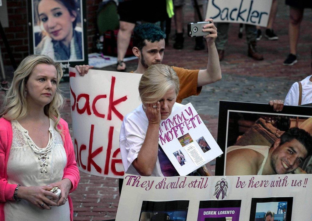 FILE - Protesters who have lost love ones to the opioid crisis protest outside a courthouse in Boston, Aug. 2, 2019, where a judge heard arguments in a lawsuit against Purdue Pharma. (AP Photo/Charles Krupa, File)