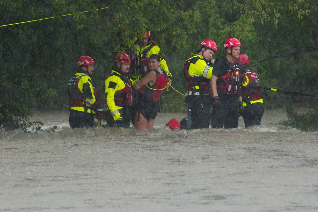 Members of the Boerne Fire Dept. rescue a woman from flood waters on Wednesday, July 15, 2026, in Boerne, Texas. (AP Photo/Darren Abate)