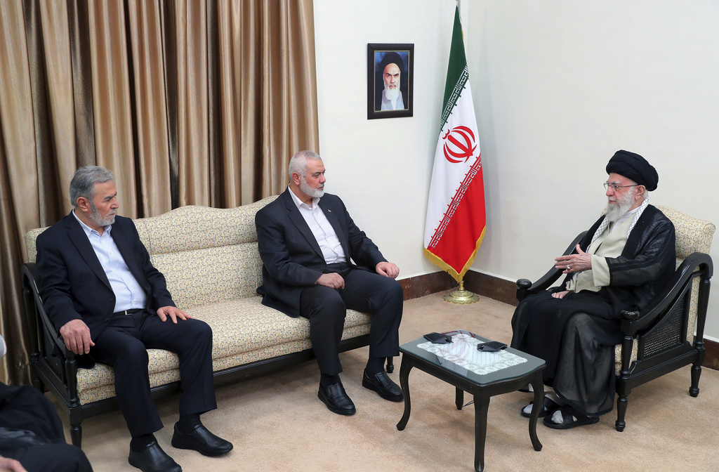 FILE - In this photo released by the office of the Iranian supreme leader, Supreme Leader Ayatollah Ali Khamenei, right, speaks with Hamas chief Ismail Haniyeh, center, and the leader of the Palestinian Islamic Jihad group Ziad Nakhaleh in their meeting in Tehran, Iran, July 30, 2024. A portrait of the late Iranian revolutionary founder Ayatollah Khomeini hangs on the wall. (Office of the Iranian Supreme Leader via AP, File)