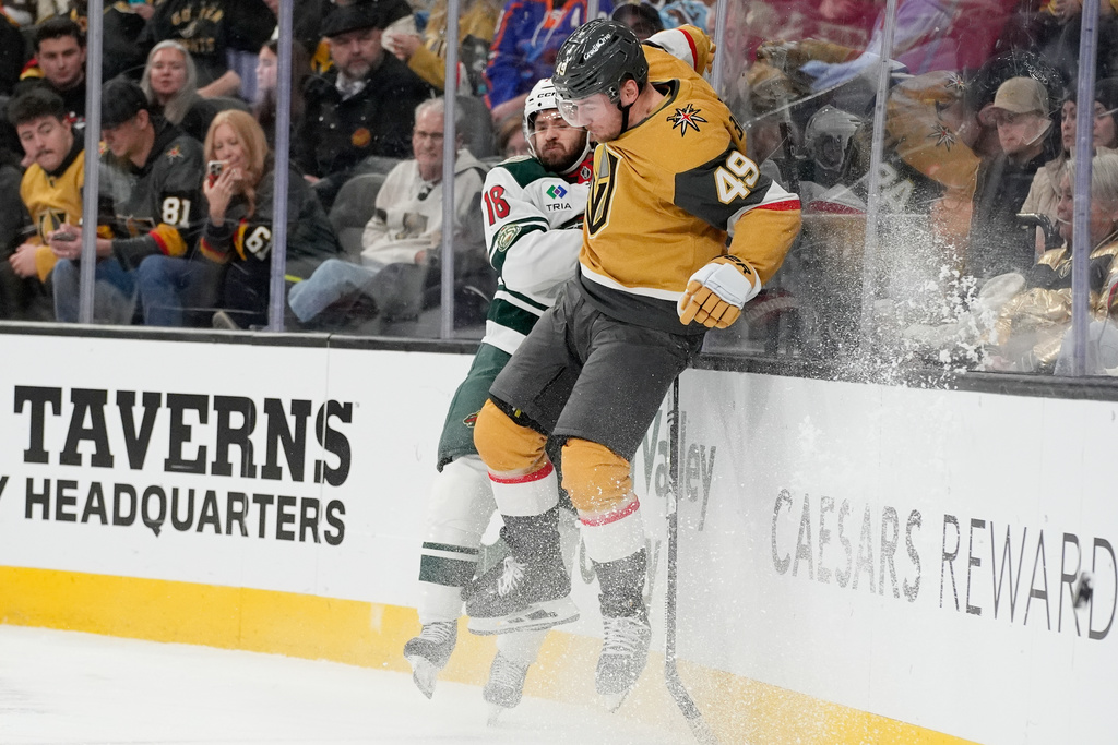 Minnesota Wild center Vinnie Hinostroza (18) and Vegas Golden Knights left wing Ivan Barbashev (49) collide during the second period of an NHL hockey game Monday, Dec. 29, 2025, in Las Vegas. (AP Photo/John Locher)