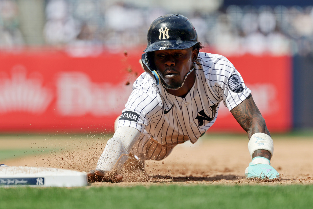 New York Yankees' Jazz Chisholm Jr. dives safely back to first base during the seventh inning of a baseball game against the Cleveland Guardians, Thursday, June 4, 2026, in New York. (AP Photo/Adam Hunger)