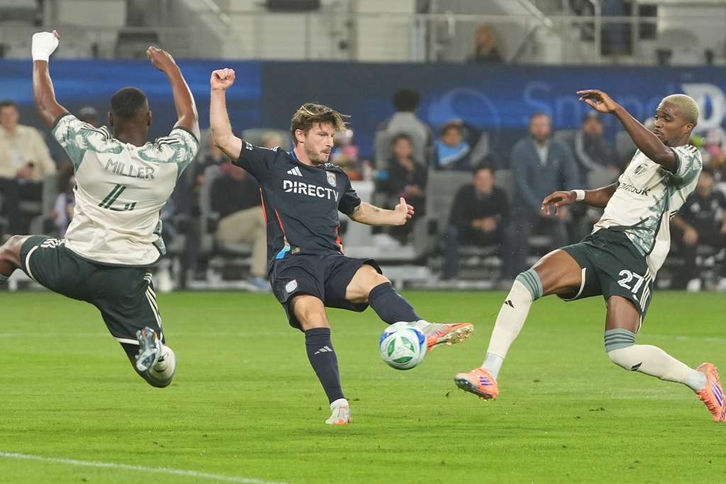 San Diego FC midfielder Anders Dreyer, center, scores a goal as Portland Timbers defender Kamal Miller, left, and Jimer Fory defend during the first half of Game 3 in the first round of MLS soccer's Western Conference playoffs Sunday, Nov. 9, 2025, in San Diego. (AP Photo/Gregory Bull)