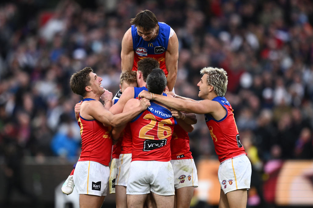 Brisbane Lions Eric Hipwood, top, celebrates with teammates after their win over the Fremantle Dockers in the Australian Football League grand final in Melbourne, Australia Saturday, Sept. 26, 2026. (Joel Carrett/AAP Image via AP)