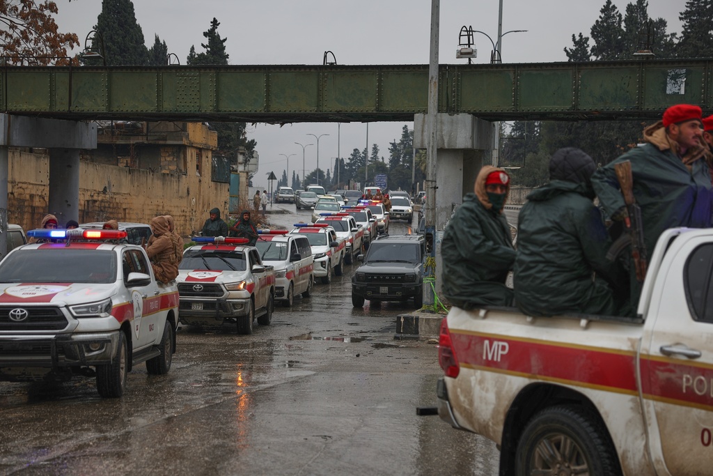 A Syrian military police convoy enters the Sheikh Maqsoud neighborhood, where clashes between government forces and Kurdish fighters have been taking place in the northern city of Aleppo, Syria, Sunday, Jan. 11, 2026. (AP Photo/Ghaith Alsayed)