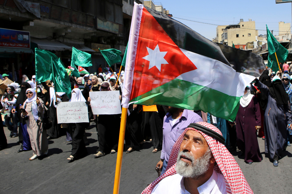 FILE -- A Jordanian protester carries the national flag during a rally by the Muslim Brotherhood, in Amman, Jordan, July 31, 2015. (AP Photo/Raad Adayleh, File)