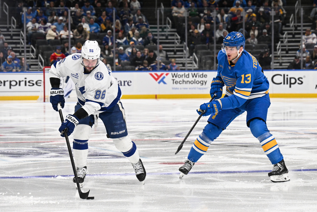 St. Louis Blues' Alexey Toropchenko (13) watches as Tampa Bay Lightning's Nikita Kucherov (86) handles the puck during the third period of an NHL hockey game Friday, Jan. 16, 2026, in St. Louis. (AP Photo/Connor Hamilton)