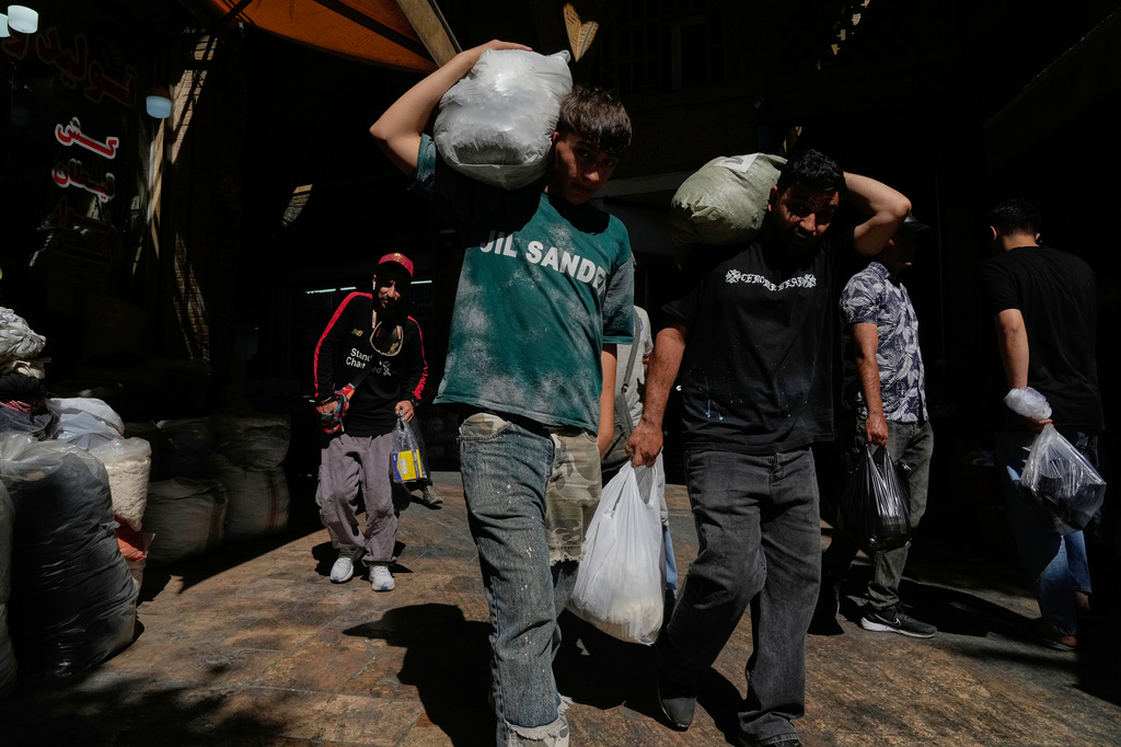 People carry packages at Tehran's historic Grand Bazaar, Iran, Monday, June 1, 2026. (AP Photo/Vahid Salemi)