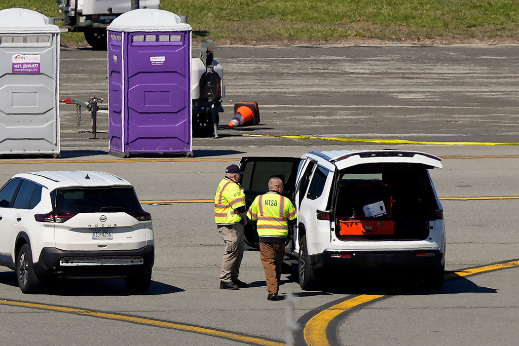 NTSB officials arrive to inspect the wreckage of an Air Canada Express jet, Tuesday, March 24, 2026, just off the runway where it had collided with a Port Authority fire truck Sunday night at LaGuardia Airport in New York. (AP Photo/Yuki Iwamura)