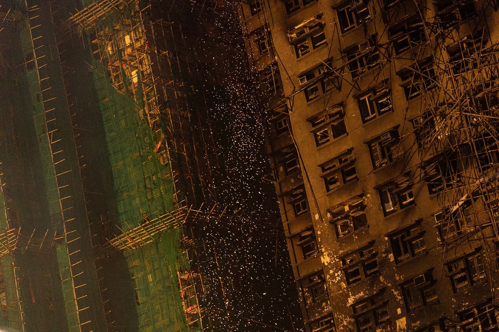 Fire sparks coming off from the burned building at the fire scene at Wang Fuk Court, a residential estate in the Tai Po district of Hong Kong's New Territories, Thursday, Nov. 27 2025. (AP Photo/Chan Long Hei)