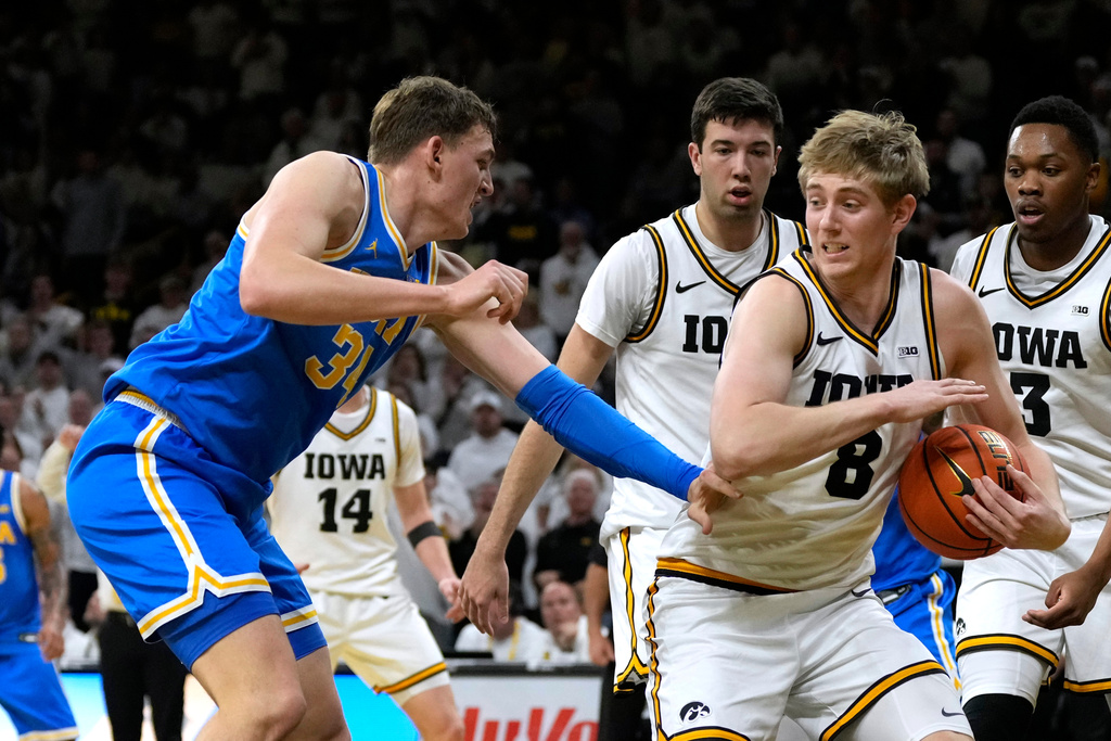 Iowa forward Cooper Koch (8) fights for a loose ball with UCLA forward Tyler Bilodeau (34) during the first half of an NCAA college basketball game, Saturday, Jan. 3, 2026, in Iowa City, Iowa. (AP Photo/Charlie Neibergall)