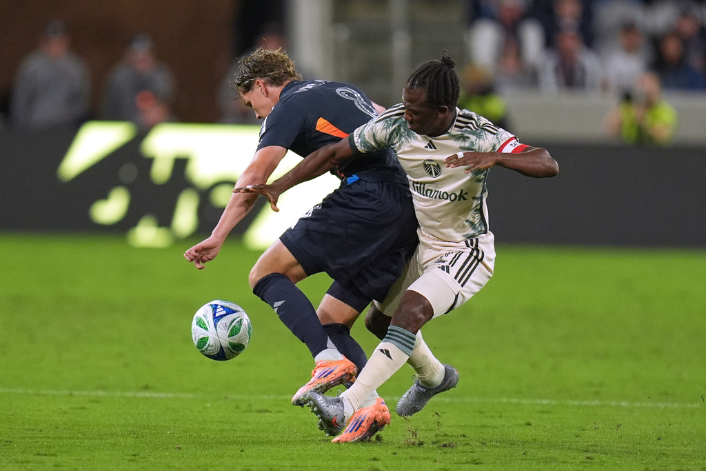 San Diego FC midfielder Onni Valakari, left, battles Portland Timbers midfielder Diego Chará for the ball during the first half of Game 1 in the first round of MLS soccer's Western Conference playoff Sunday, Oct. 26, 2025, in San Diego. (AP Photo/Gregory Bull)
