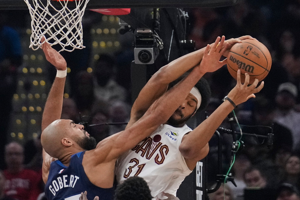 Minnesota Timberwolves center Rudy Gobert, left, fouls Cleveland Cavaliers center Jarrett Allen, right, in the first half of an NBA basketball game Sunday, Jan. 4, 2026, in Cleveland. (AP Photo/Sue Ogrocki)