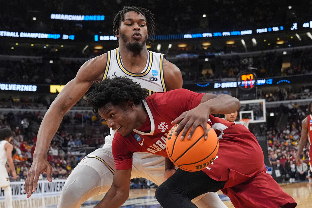 Alabama's London Jemison, front, drives past Michigan's Morez Johnson Jr. during the second half in the Sweet 16 of the NCAA college basketball tournament, Friday, March 27, 2026, in Chicago. (AP Photo/Nam Y. Huh)