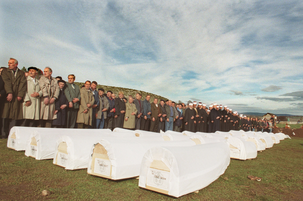 FILE - Friends and relatives join Muslim clerics in prayer over the coffins of Muslim men who died in 1992, for their final burial in Novoseoci, Bosnia-Herzegovina, on Nov. 5, 2000. (AP Photo/Jerome Delay, File)