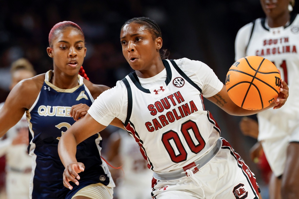 South Carolina guard Ta'Niya Latson (00) drives to the basket against Queens of Charlotte guard Jermany Mapp, left, during the first half of an NCAA college basketball game in Columbia, S.C., Sunday, Nov. 23, 2025. (AP Photo/Nell Redmond)