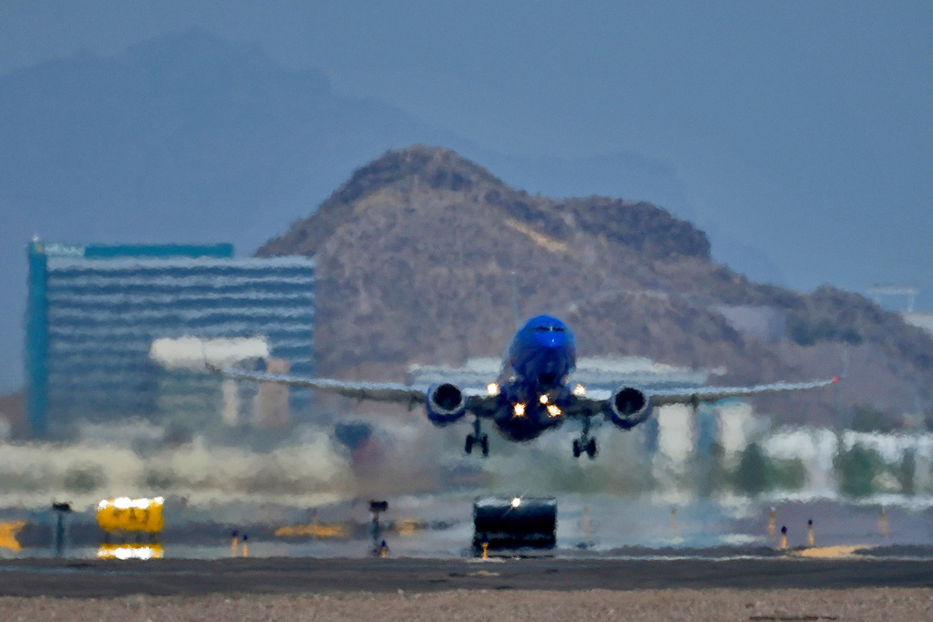 FILE - A jet takes flight as heat ripples radiate from the runway at Sky Harbor International Airport in Phoenix, on July 25, 2023. (AP Photo/Matt York, File)