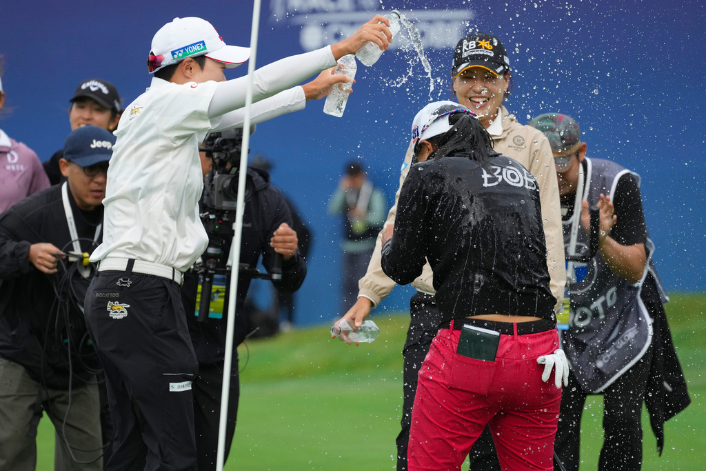 Sei Young Kim of South Korea, right, celebrates after winning the LPGA Ladies Championship golf tournament at the Pine Beach Golf Links, in Haenam, South Korea, Sunday, Oct. 19, 2025. (AP Photo/Lee Jin-man)