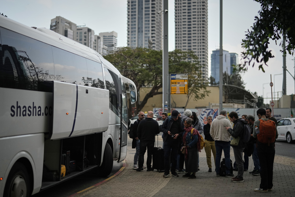 Tourists board buses bound for the Taba border crossing with Egypt to leave Israel after Israeli airspace was closed amid the war with Iran, in Tel Aviv, Israel, Wednesday, March 4, 2026. (AP Photo/Leo Correa)