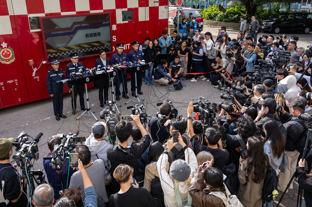 FILE- Hong Kong Secretary for Security Chris Tang, third from left at rear, speaks to the members of media after a deadly fire at Wang Fuk Court, a residential estate in the Tai Po district of Hong Kong's New Territories, Nov. 28, 2025. (AP Photo/Chan Long Hei, File)