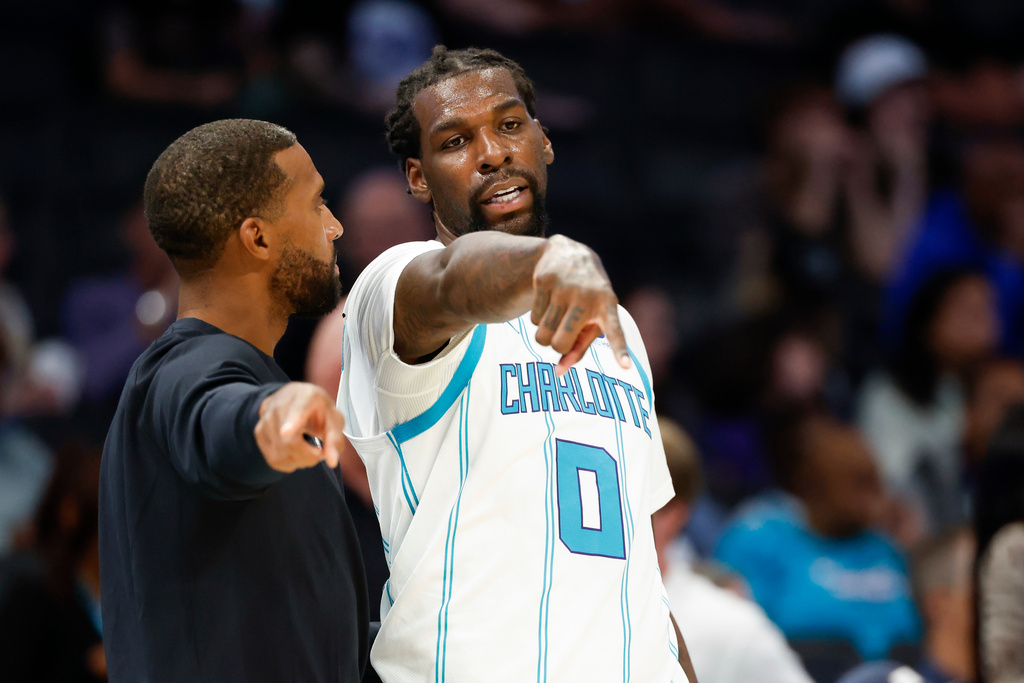 Charlotte Hornets head coach Charles Lee, left, talks to forward Naz Reid during the first half of a preseason NBA basketball game against the Brooklyn Nets in Charlotte, N.C., Tuesday, Oct. 6, 2026. (AP Photo/Nell Redmond)