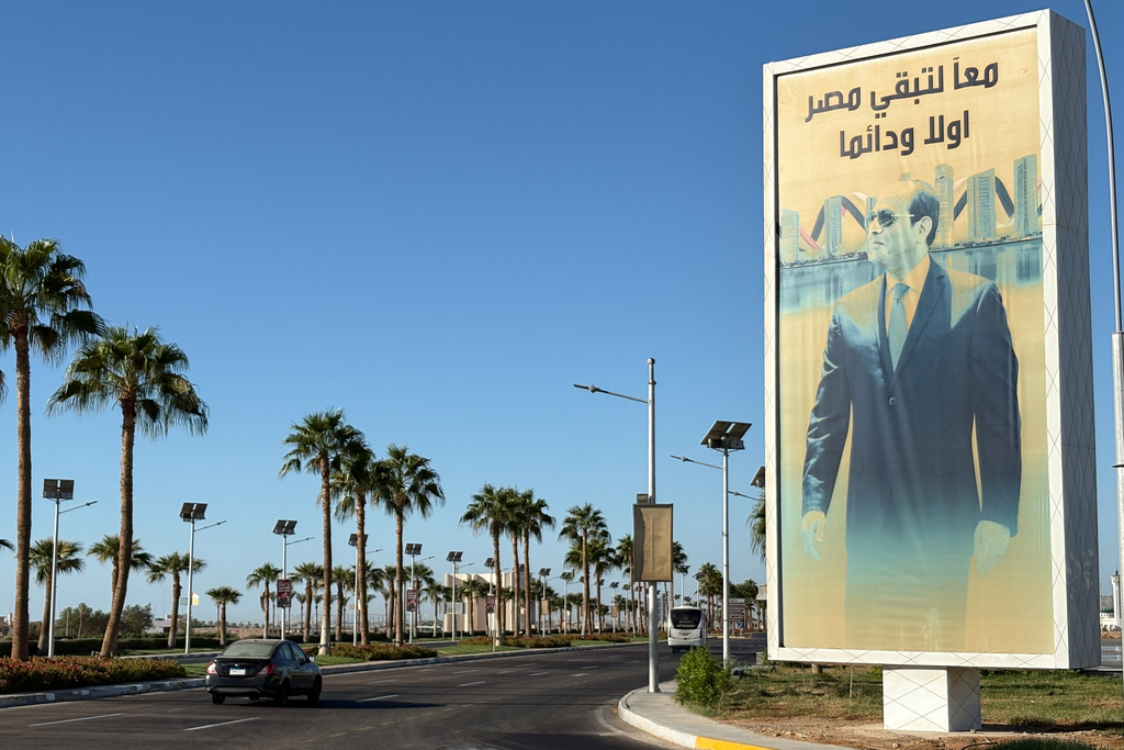 A vehicle passes in front of a billboard showing Egyptian President Abdel Fattah el-Sissi at the Red Sea city of Sharm el-Sheikh, Egypt, where Israeli and Hamas officials are set to hold indirect talks, Wednesday, Oct. 8, 2025. Arabic reads, "together Egypt will remain forever". (AP Photo)