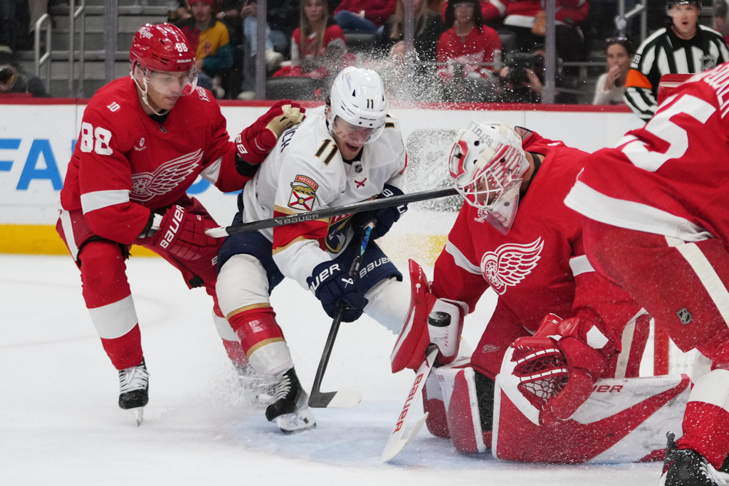 Detroit Red Wings goaltender Cam Talbot (39) stops a Florida Panthers right wing Mackie Samoskevich (11) shot as Patrick Kane (88) defends in the first period of an NHL hockey game Wednesday, Oct. 15, 2025, in Detroit. (AP Photo/Paul Sancya)