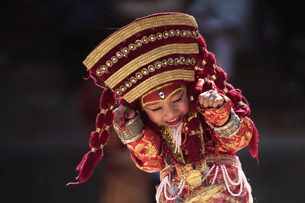 A young Newar girl, dressed to represent divine female energy, reacts as she waits for Kumari Puja, a ritual during which she would be worshipped, at Hanuman Dhoka, Basantapur Durbar Square, Kathmandu, Nepal, Friday, Sept. 5, 2025. (AP Photo/Niranjan Shrestha)