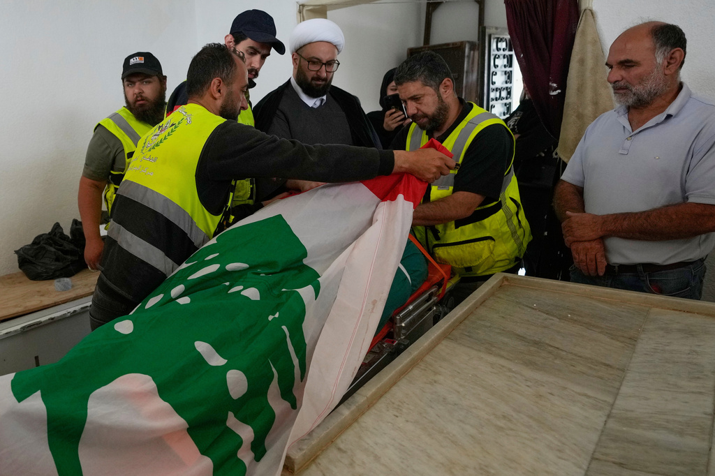 Paramedics cover the body of Ghadir Baalbaki, 19, who was killed on Tuesday in an Israeli airstrike, with a Lebanese flag at a morgue in the southern port city of Tyre, Lebanon, Wednesday, April 15, 2026. (AP Photo/Hussein Malla)