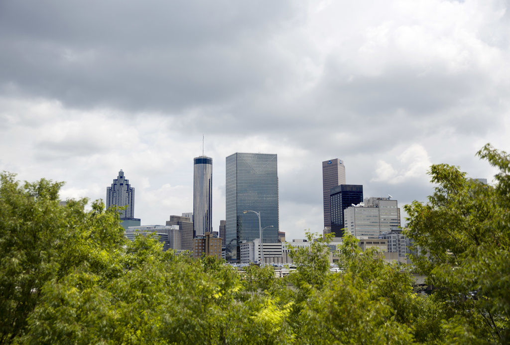 FILE - The downtown skyline rises behind a row of trees in Atlanta, June 13, 2018. (AP Photo/David Goldman, File)